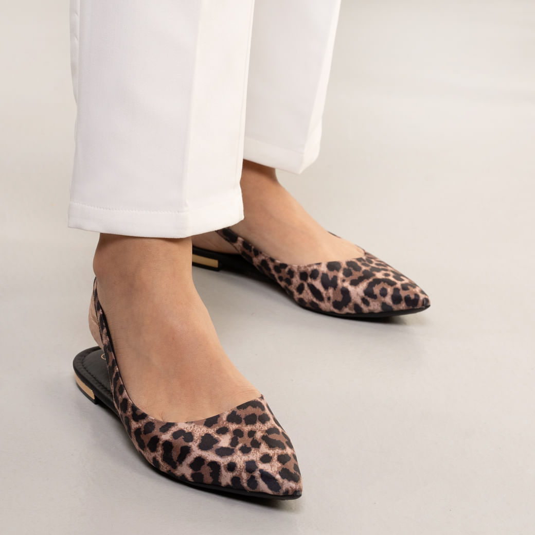 Sapatilha feminina bico fino com estampa animal print em tons bege e preto vista frontal com calça branca e tira traseira elástica