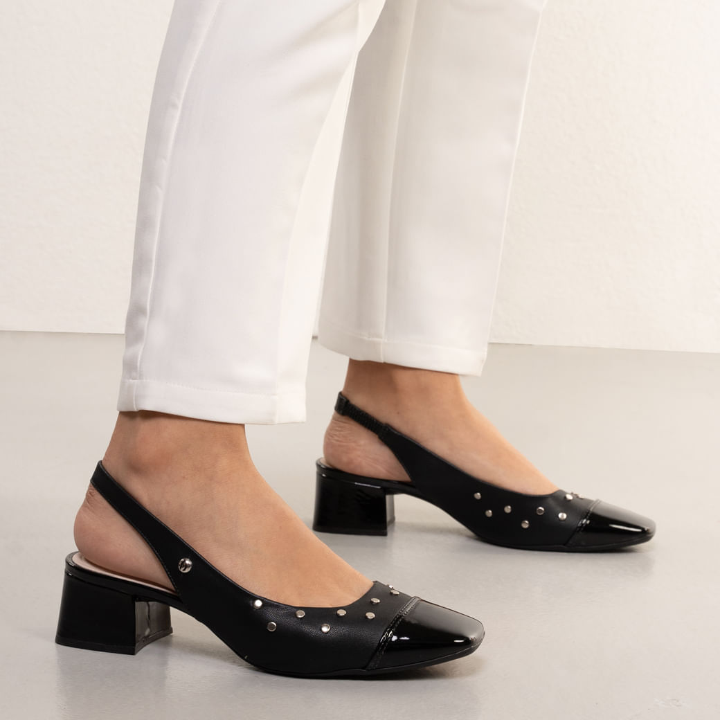 Sapato feminino preto com salto bloco, bico verniz brilhante, tachas metálicas prateadas e tira slingback elástica