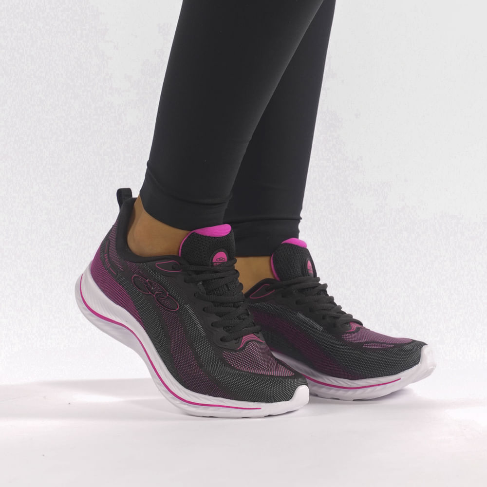 Vista lateral do tênis feminino Olympikus Apolis preto com detalhes rosa, destacando design moderno e solado antiderrapante.