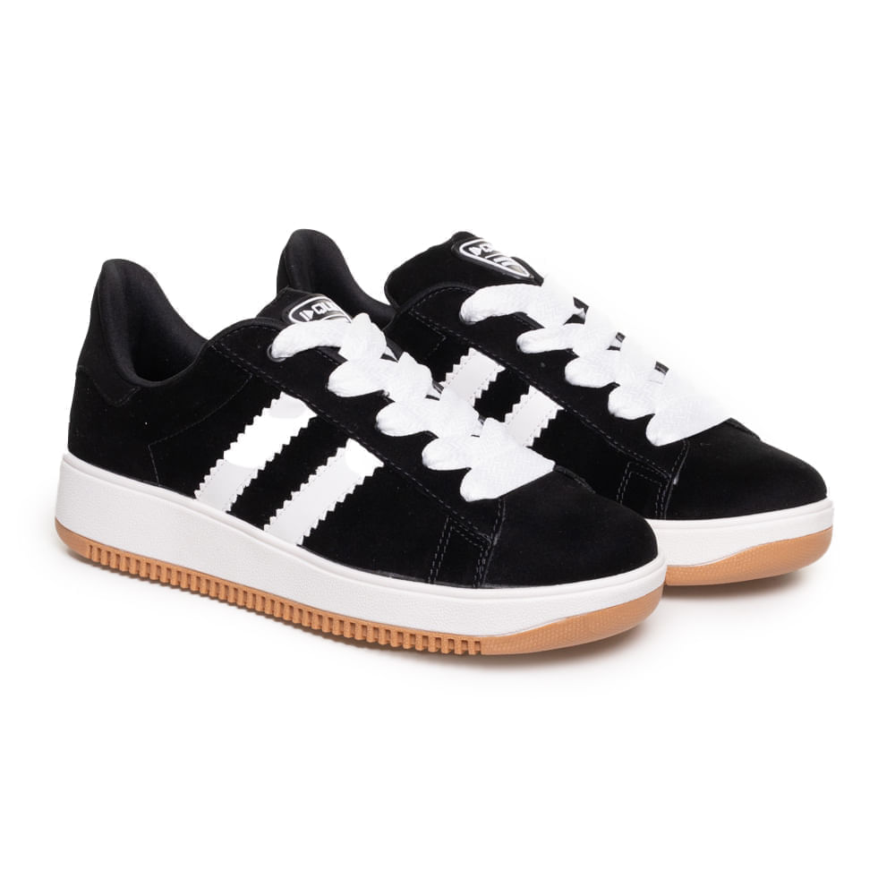 Detalhe lateral do tênis preto com listras brancas e solado caramelo antiderrapante.