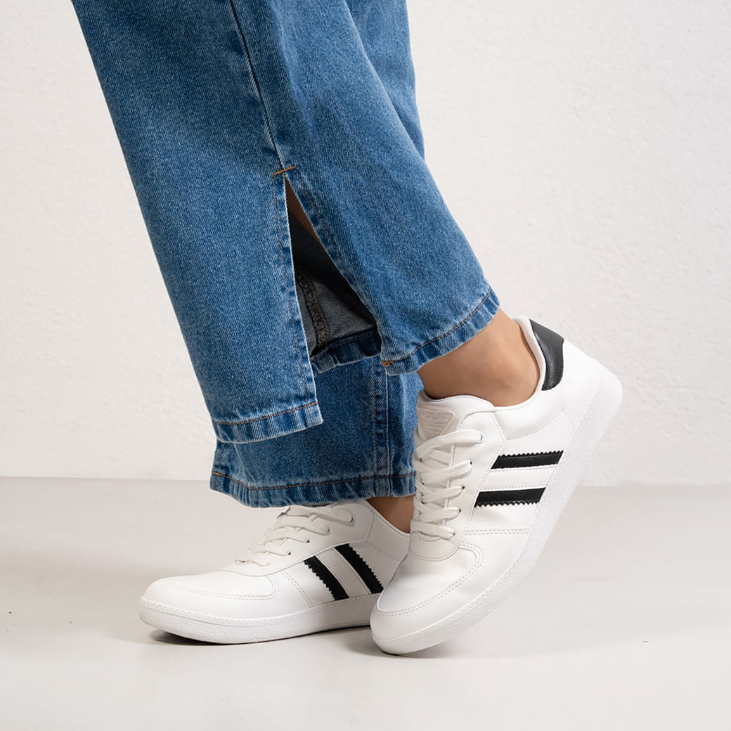 Tênis feminino preto e branco visto de frente em fundo branco