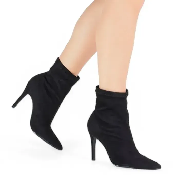 Bota feminina preta em camurça stretch vista lateral mostrando o design e salto fino