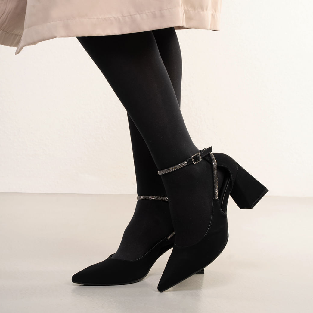 Perfil lateral do scarpin feminino preto com salto grosso e tira brilhante no tornozelo