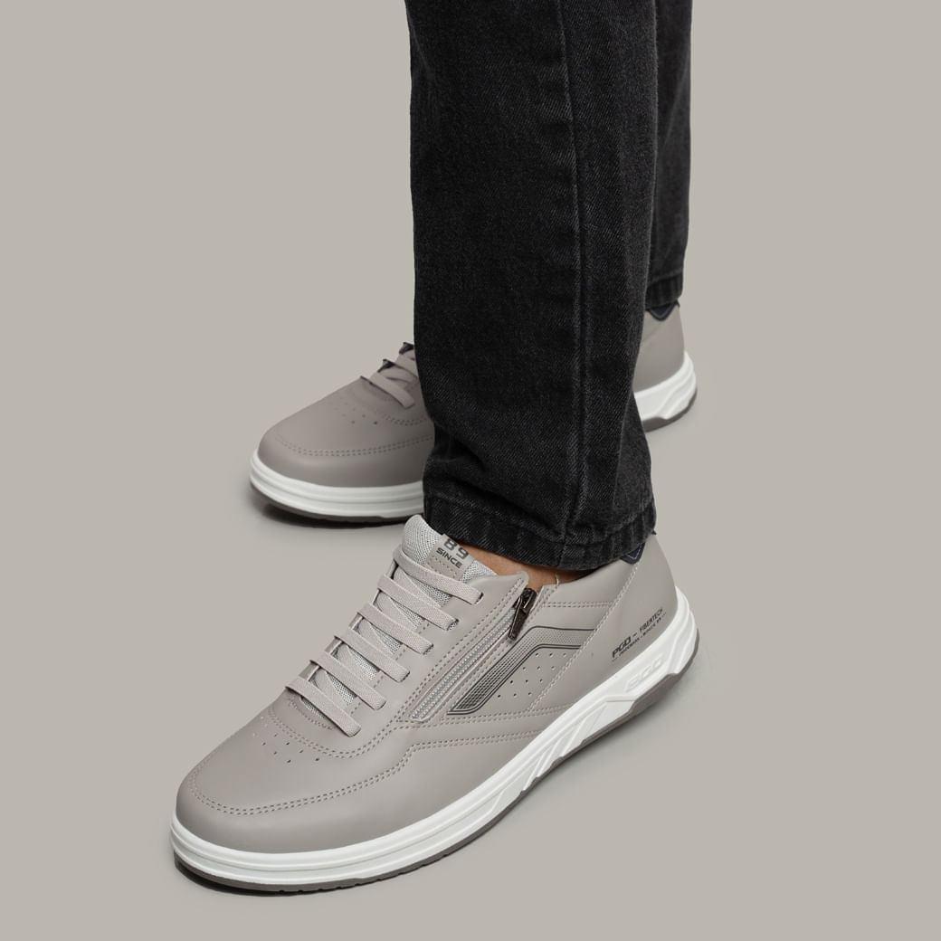 Sapatênis masculino cinza em microfibra vista lateral com cadarço e detalhe azul-marinho no calcanhar