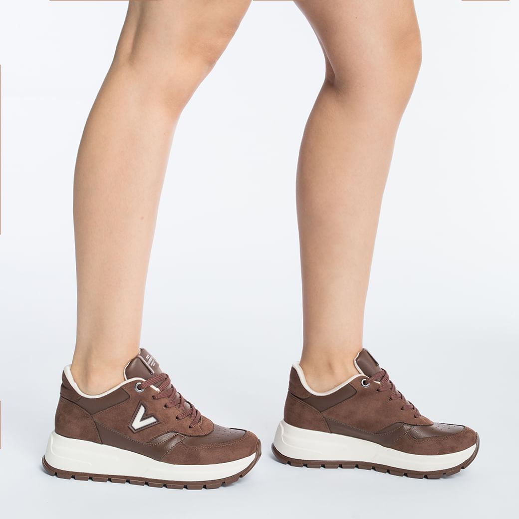 Vista lateral do tênis casual feminino marrom com sola branca e cadarço