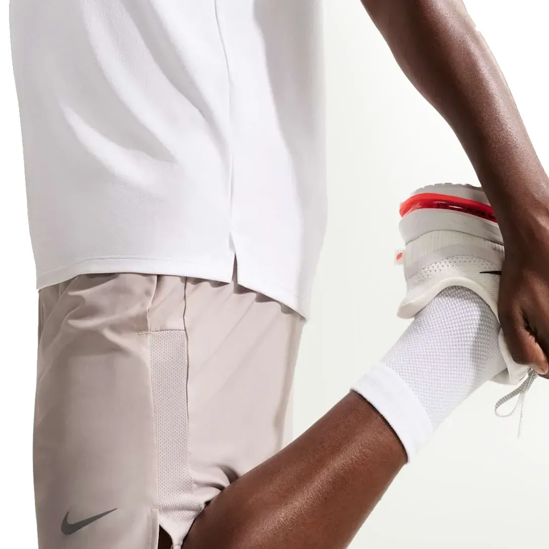 Bermuda Nike Challenger masculina bege em uso para atividades físicas