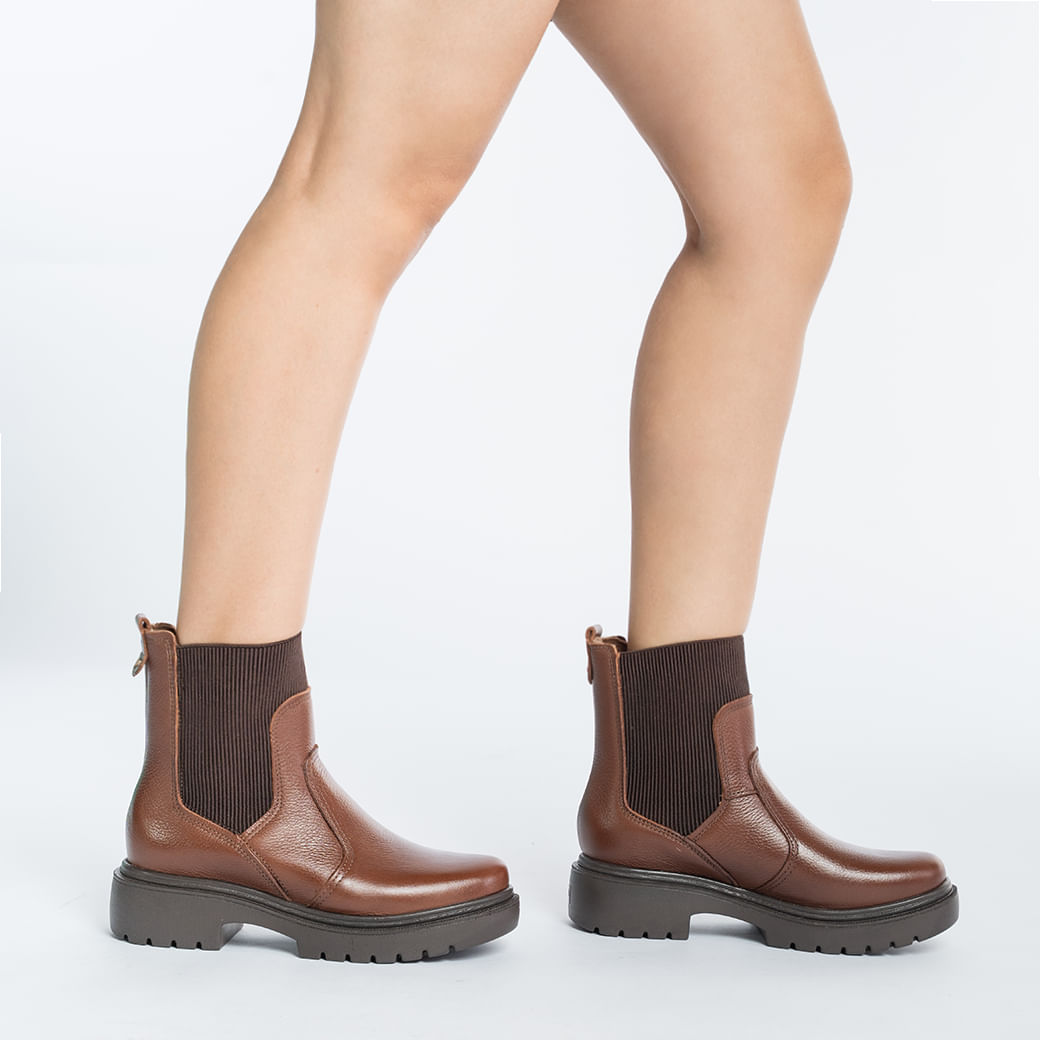 Bota coturno terracota de couro vista lateral com destaque para o solado e cano alto