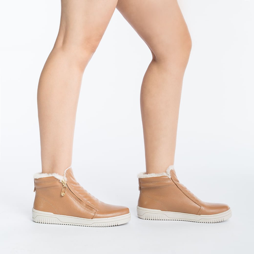 Vista lateral do tênis casual feminino Pegada em couro caramelo com detalhes em zíper dourado