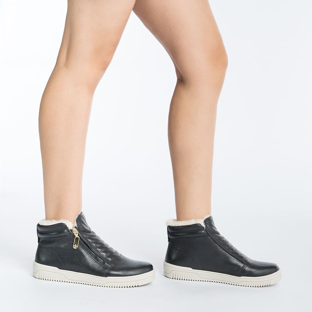 Tênis feminino casual de cano médio em couro preto com fechamento em zíper dourado, vista lateral