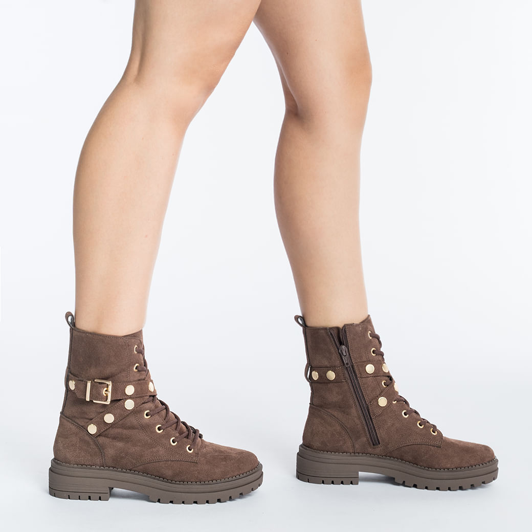 Vista lateral da bota coturno feminina marrom em camurça com detalhes em metal dourado