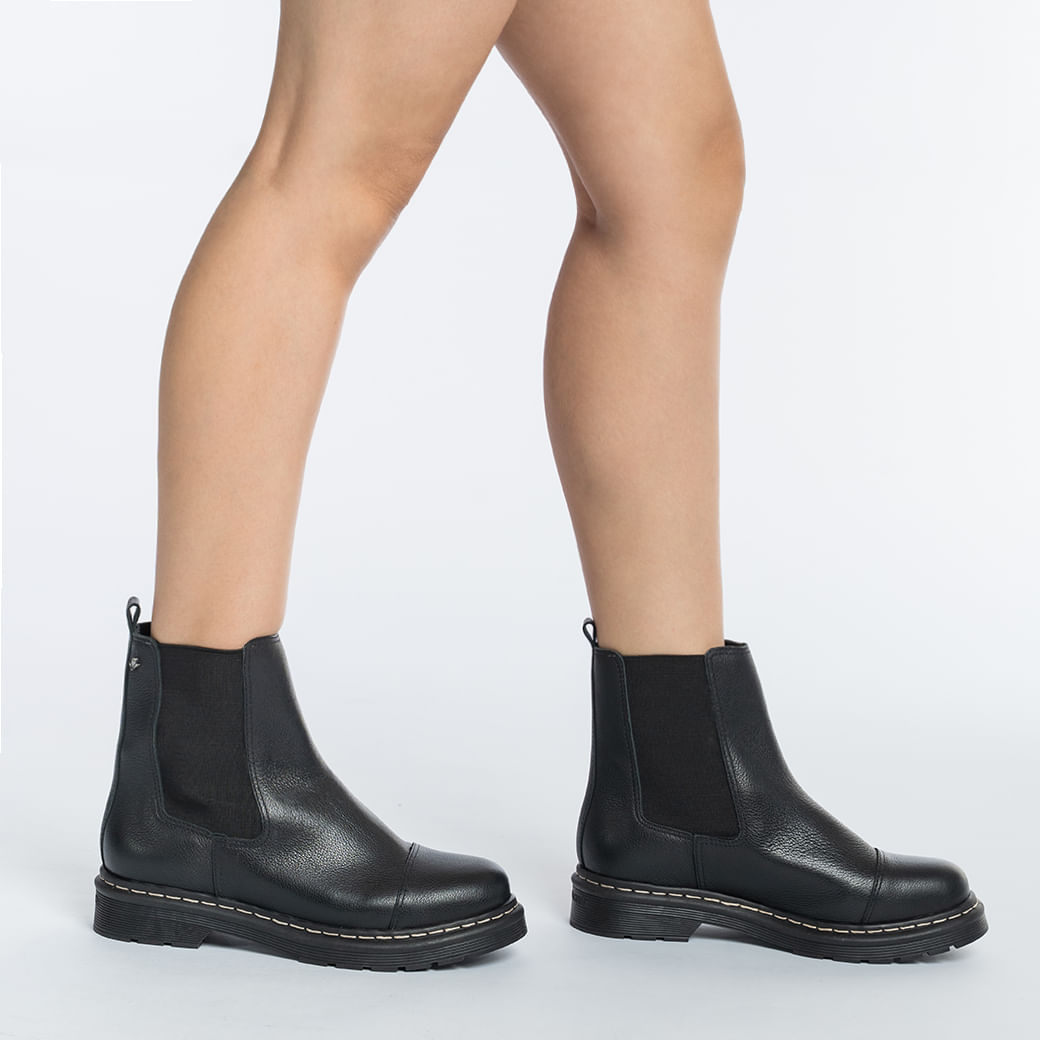 Vista lateral da bota Cravo & Canela preta com solado antiderrapante e elástico lateral