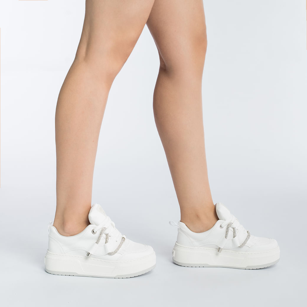 Tênis branco Via Marte com detalhes prateados, fechamento com cadarço e solado branco, ângulo lateral