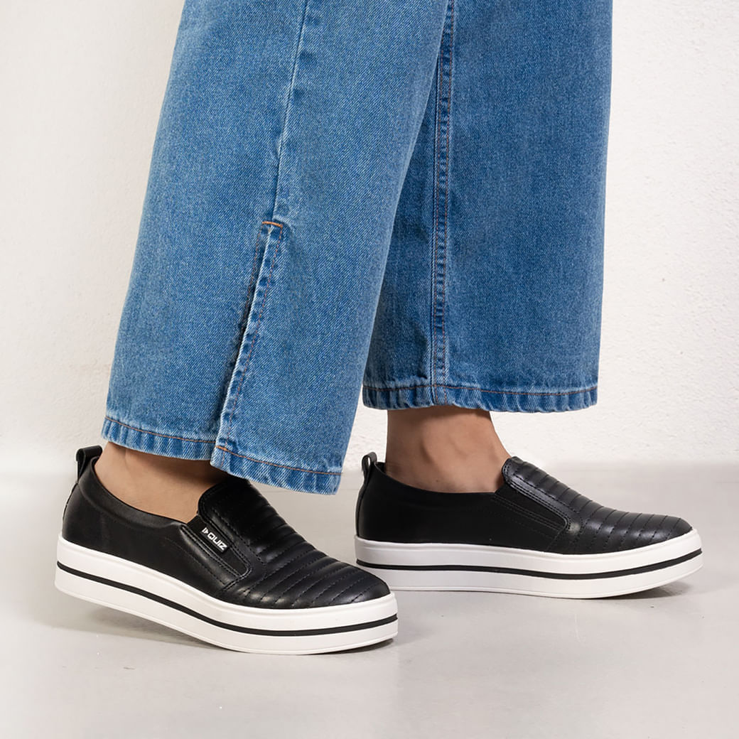 Tênis feminino slip on preto vista frontal e lateral, mostrando cabedal acolchoado e solado plataforma