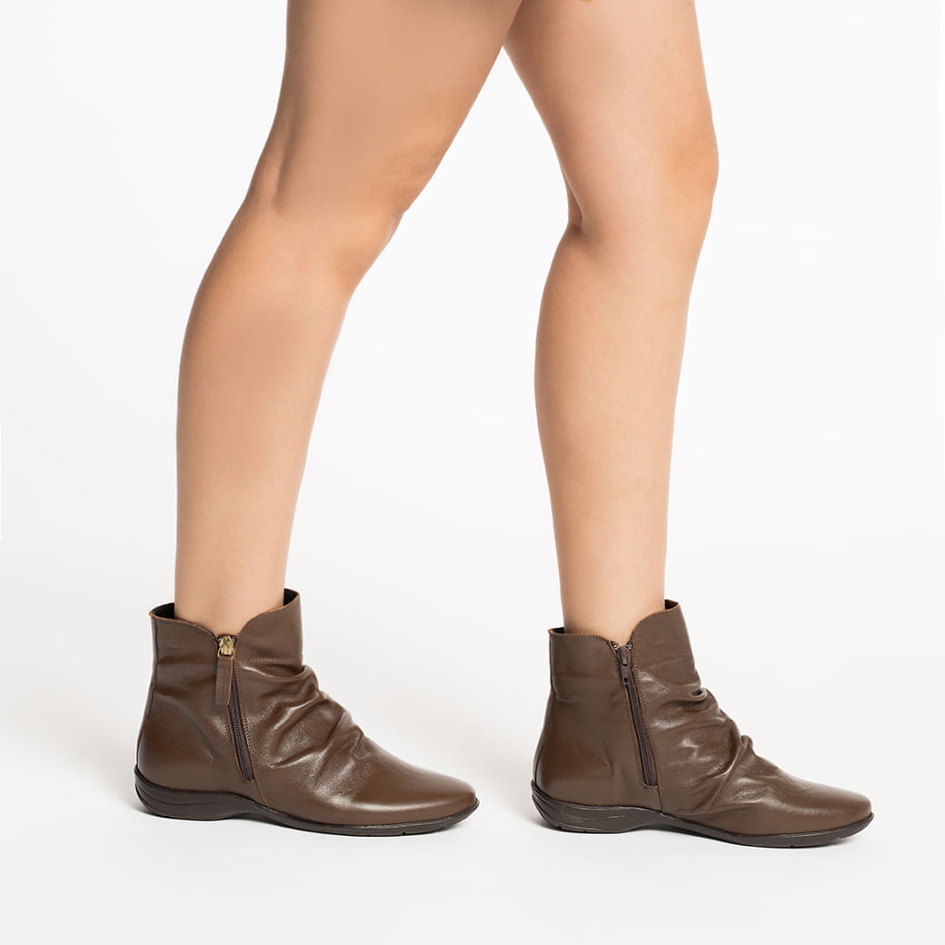 Bota feminina cano curto em couro marrom mostrando zíper lateral e costura detalhada