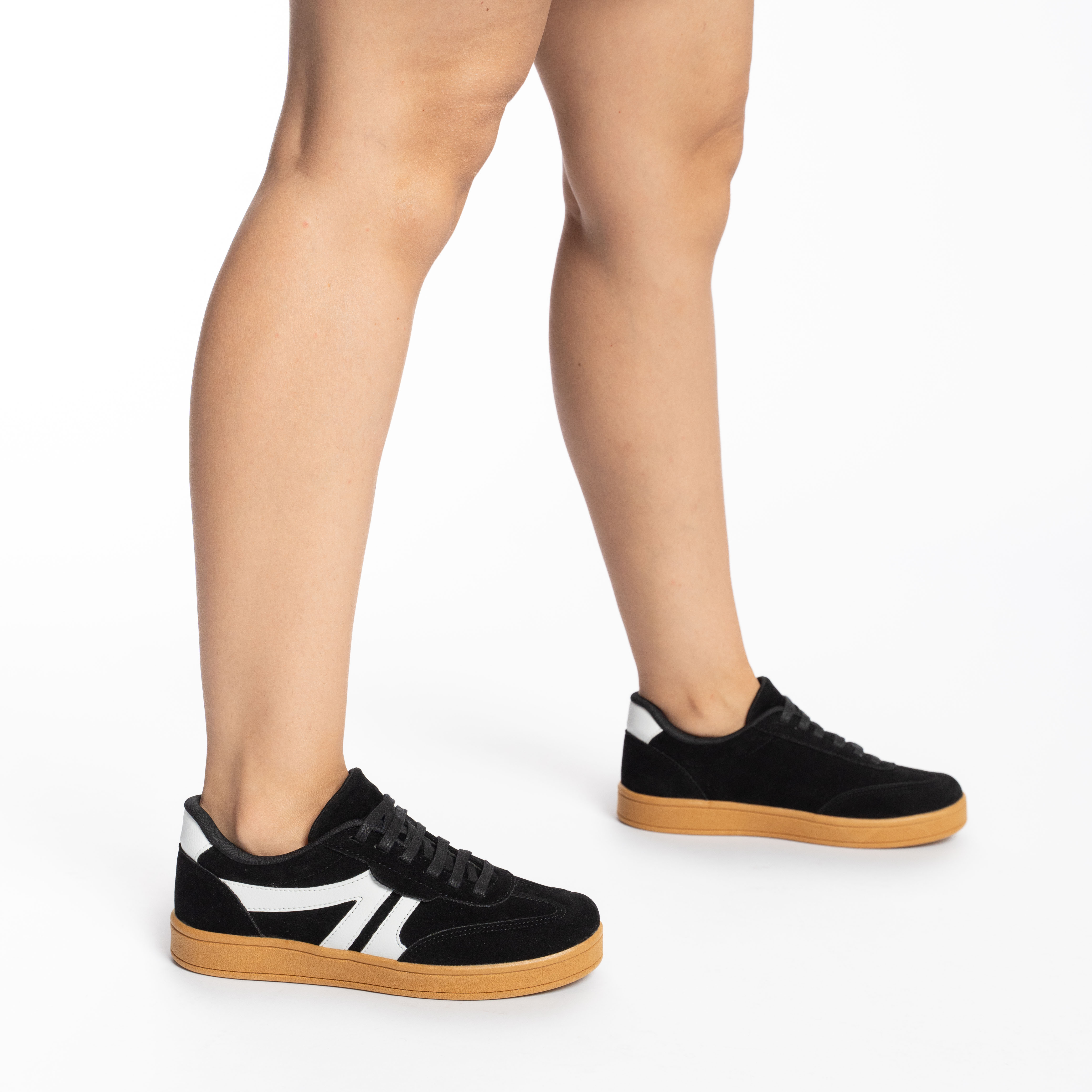 Tênis casual feminino preto visto de lado, destacando detalhes em branco e solado bege claro