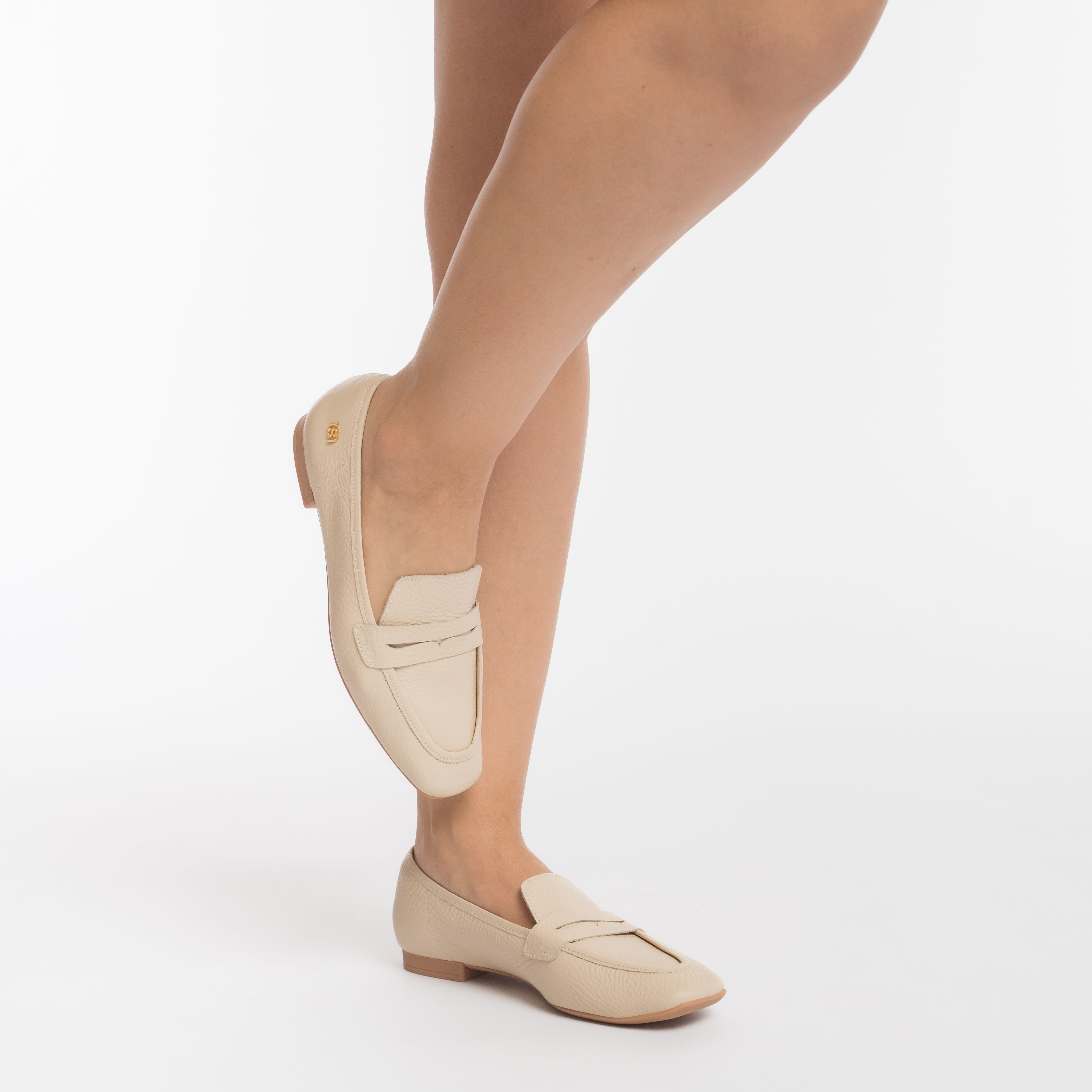 Sapato loafer feminino em couro creme com fivela central, vista lateral completa