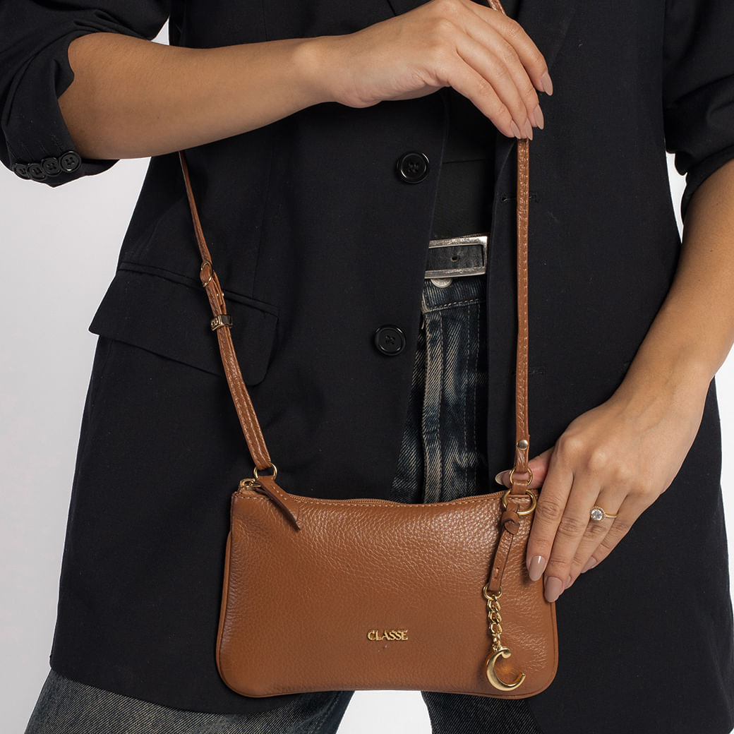 Vista lateral da bolsa crossbody Classe Couro Veta feminina caramelo com detalhes dourados