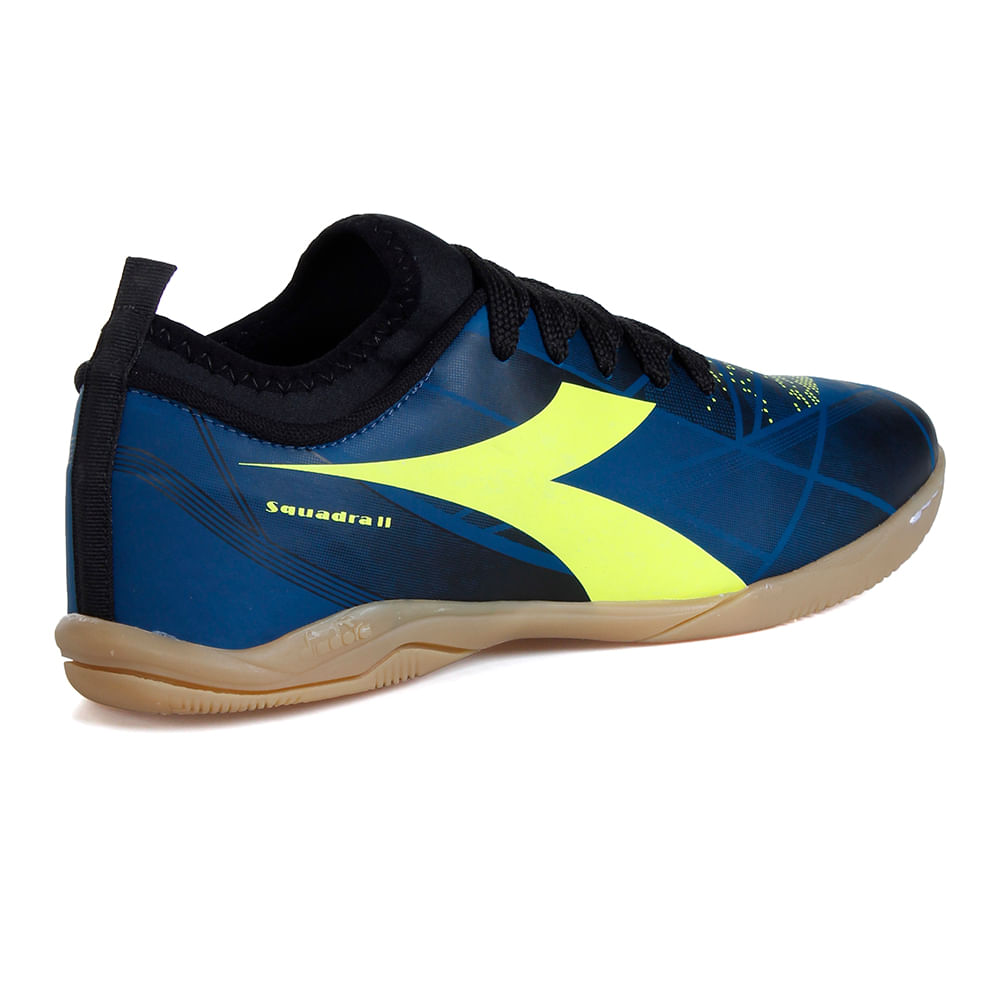 Vista lateral interna da chuteira Diadora Squadra II com grafismo amarelo e solado claro em borracha
