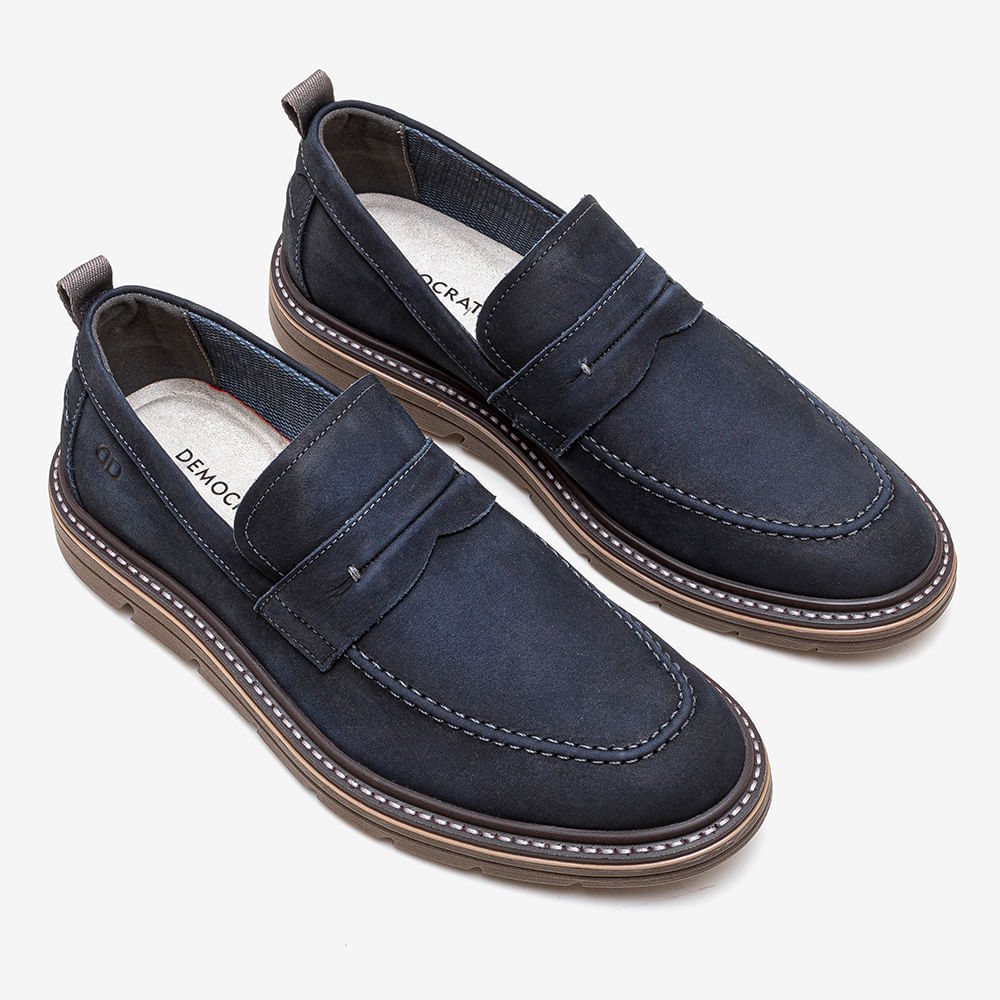 Par de sapatos casuais masculinos marinho, vistos de cima com sola marrom.