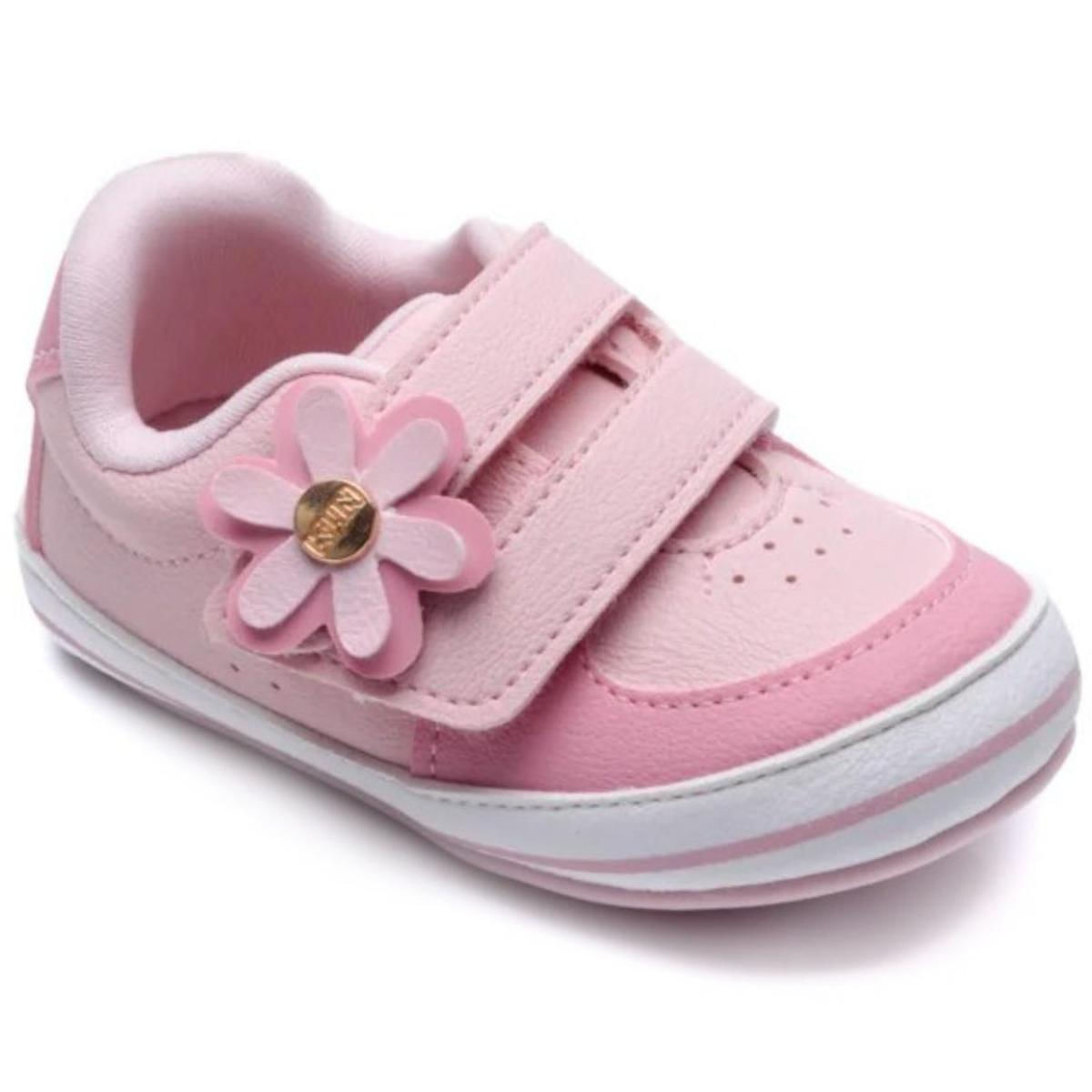 Close do tênis infantil rosa com aplique de flor e tiras de velcro