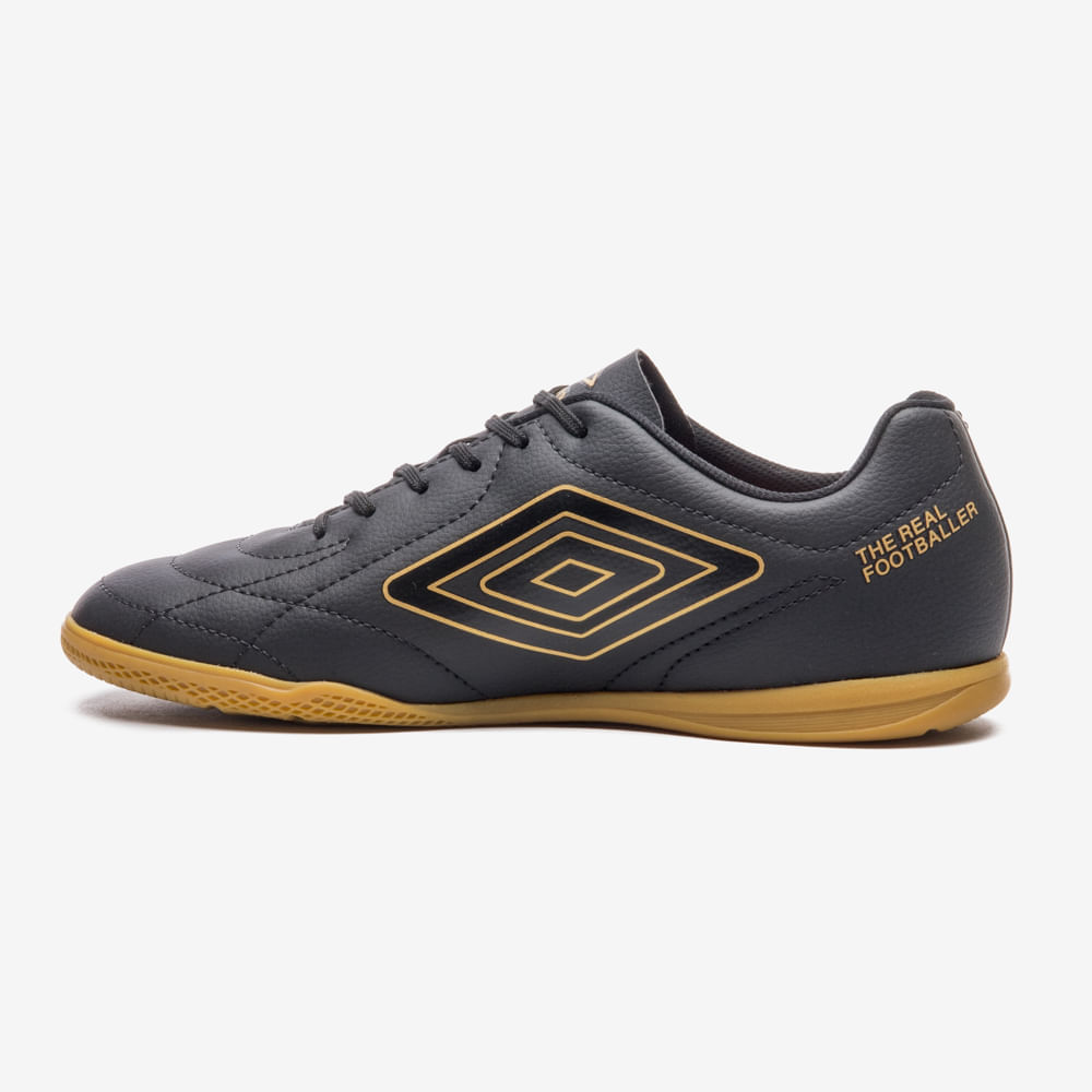 Chuteira Umbro masculina preta vista lateral direita com logo dourado e solado texturizado para melhor aderência.