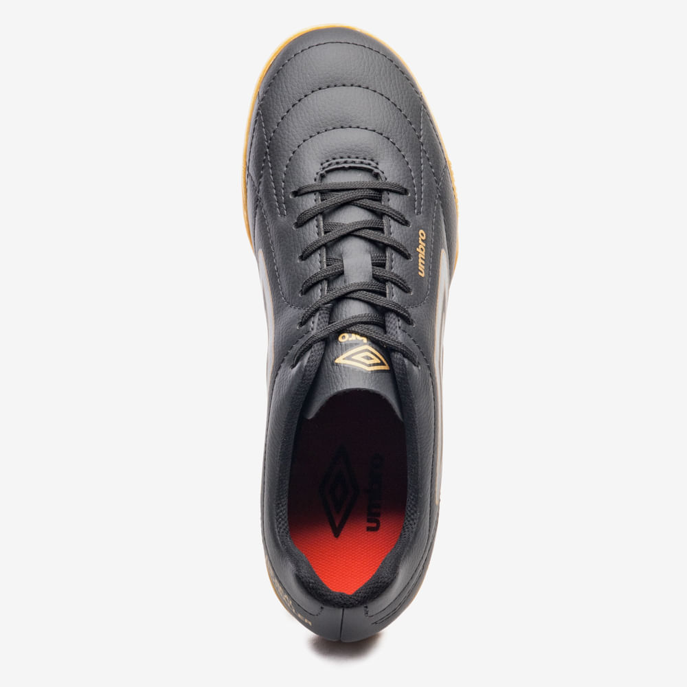 Vista superior da chuteira Umbro masculina preta com detalhes dourados mostrando cadarços e interior acolchoado.