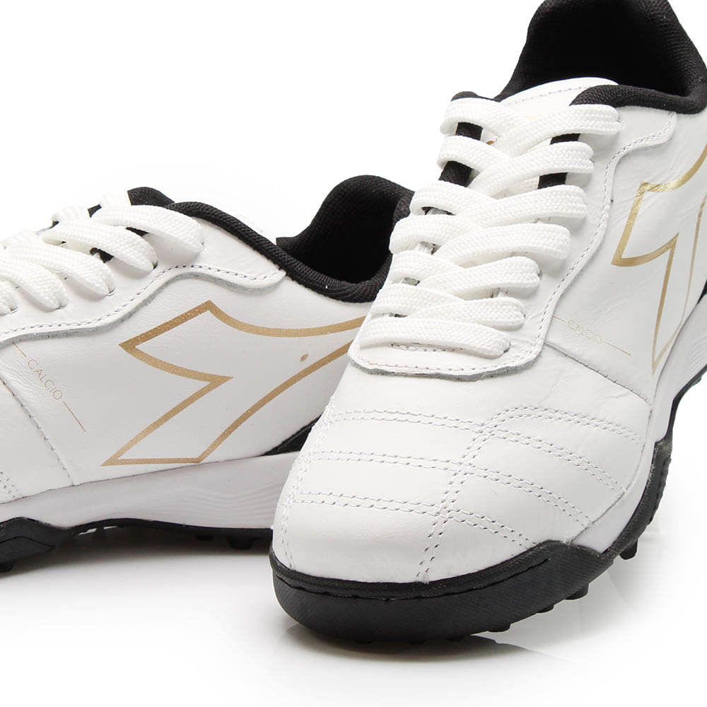 Par de chuteiras society masculinas Diadora Calcio Elite branco preto dourado close do cabedal
