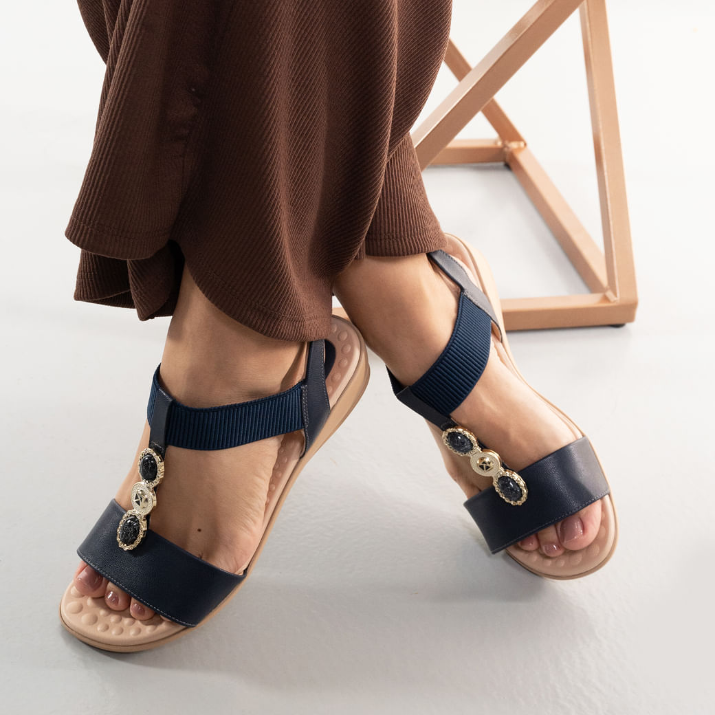 Sandália navy feminina com elástico canelado e detalhes dourados usada por modelo.