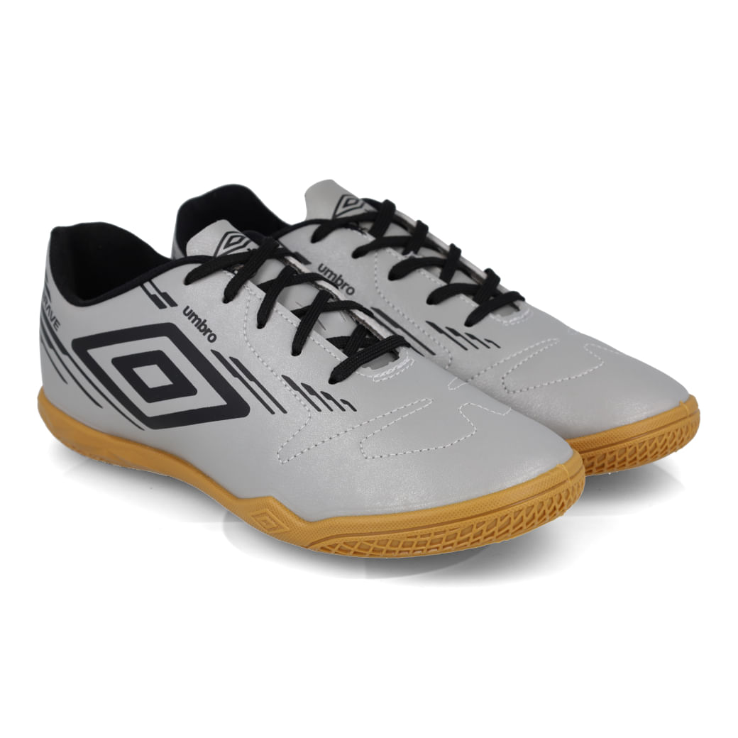Par de chuteiras futsal infantil Umbro Brave JR cinza preta com solado caramelo vista frontal