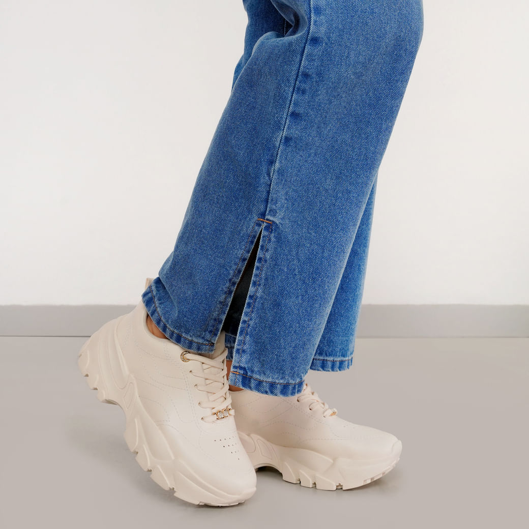 Tênis feminino off white em ângulo lateral com solado plataforma tratorado e cadarços com ilhós dourados