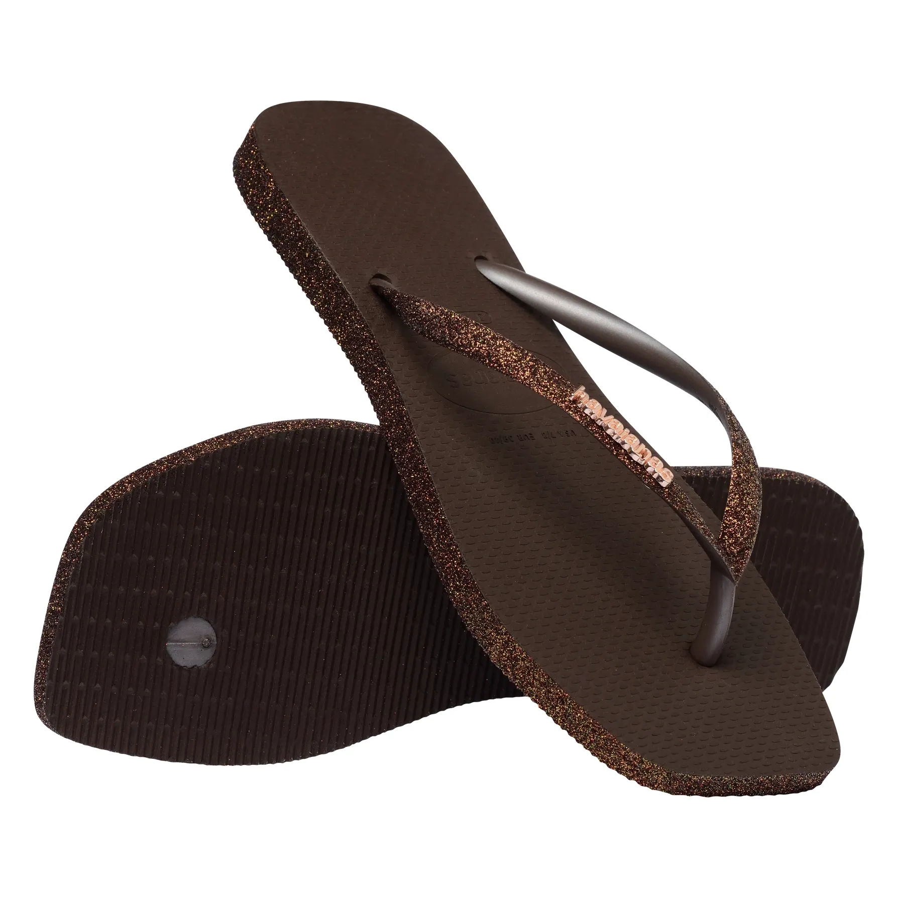 Composição de chinelos Havaianas marrom evidenciando sola e tiras brilhantes com logo metálico