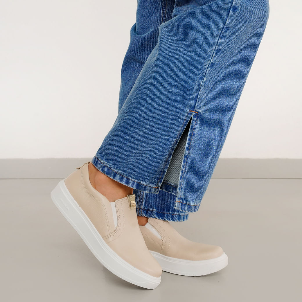 Tênis feminino Pegada cor linho/bege em close no pé, slip-on com elástico lateral e solado branco