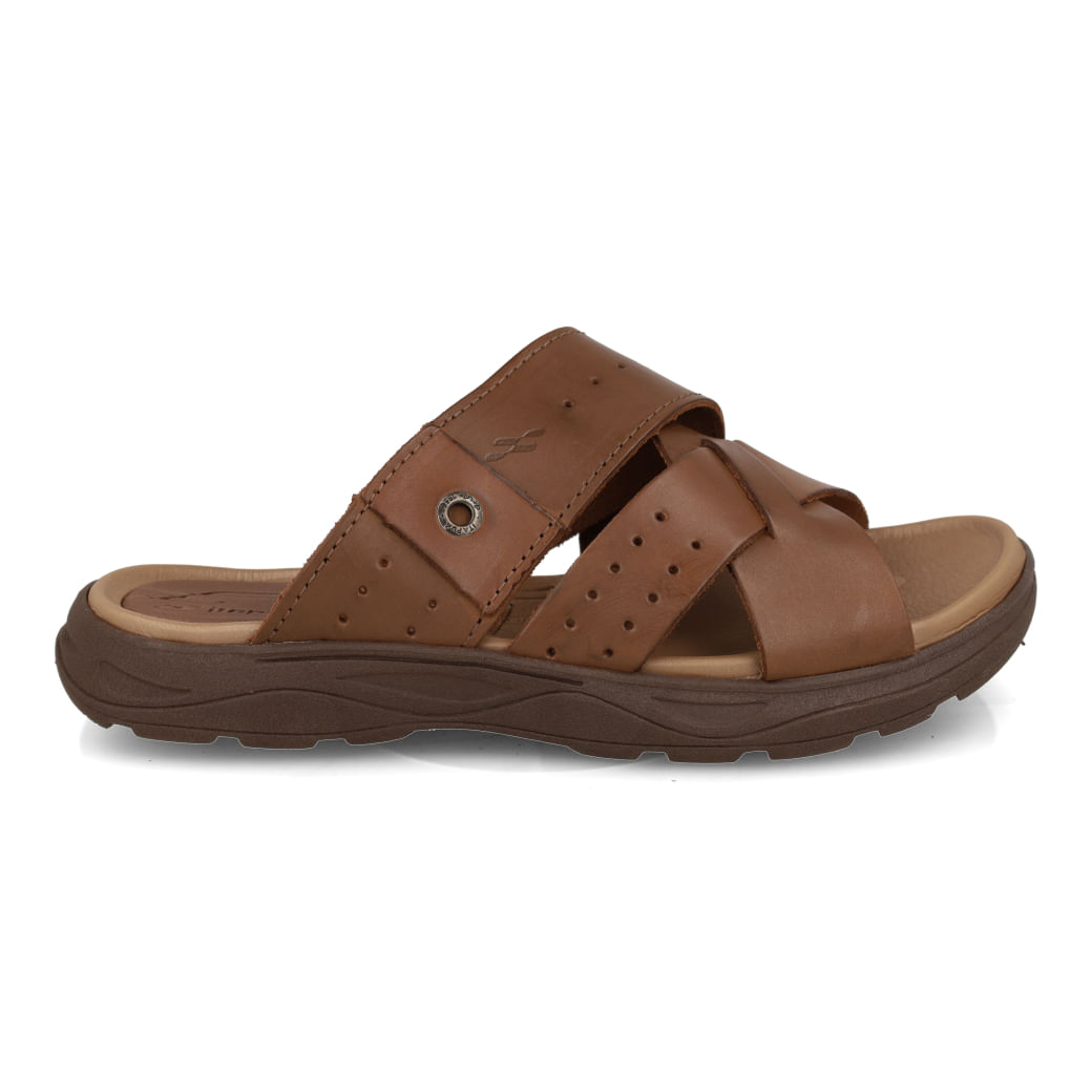 Chinelo slide masculino Itapuã em couro marrom, vista lateral direita, tiras cruzadas com perfurações e detalhe metálico circular