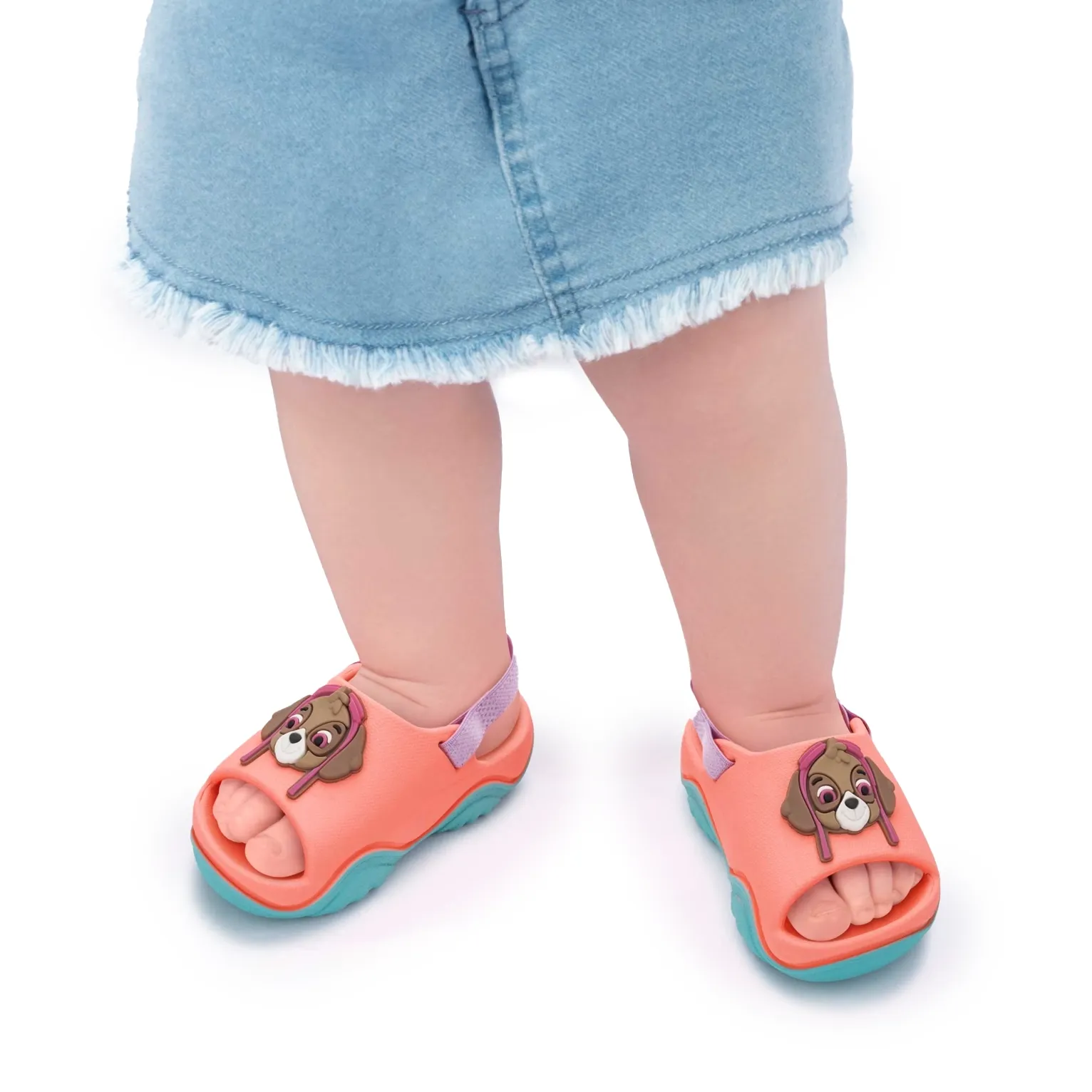 Chinelo casual infantil feminino Grendene rosa com detalhes lilás e azul, solado azul ondulado e aplique de cachorro em relevo.