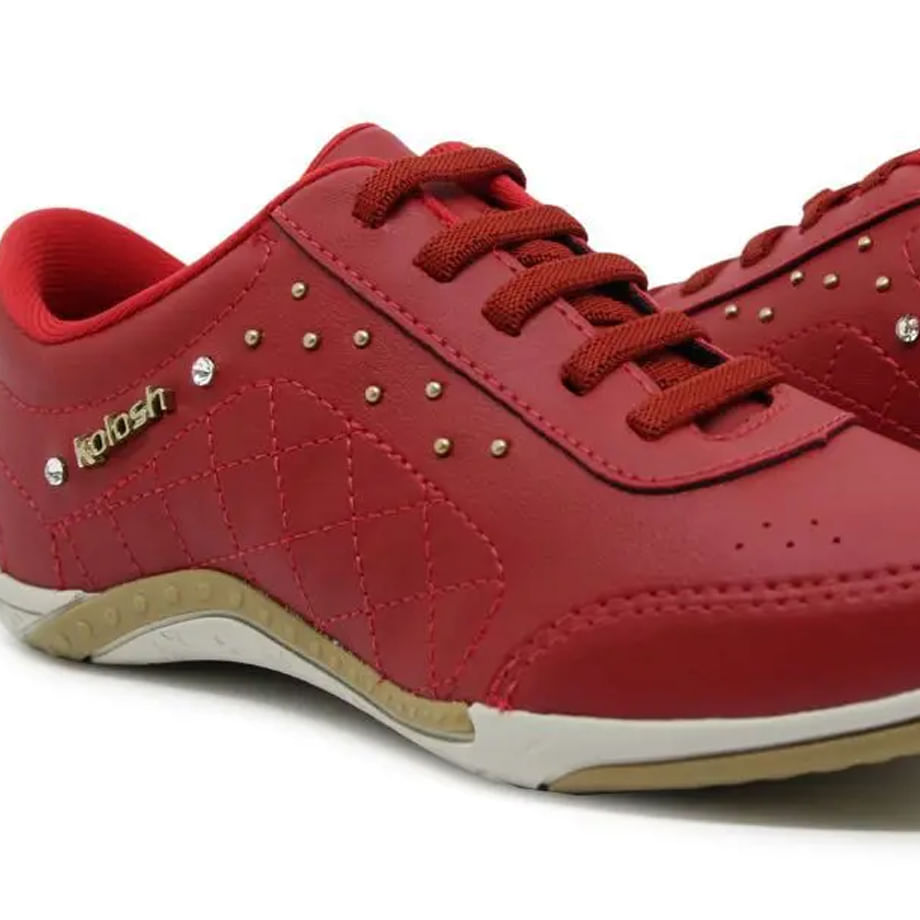 Close em tênis feminino Kolosh vermelho mostrando detalhes do cadarço, rebites dourados e strass.