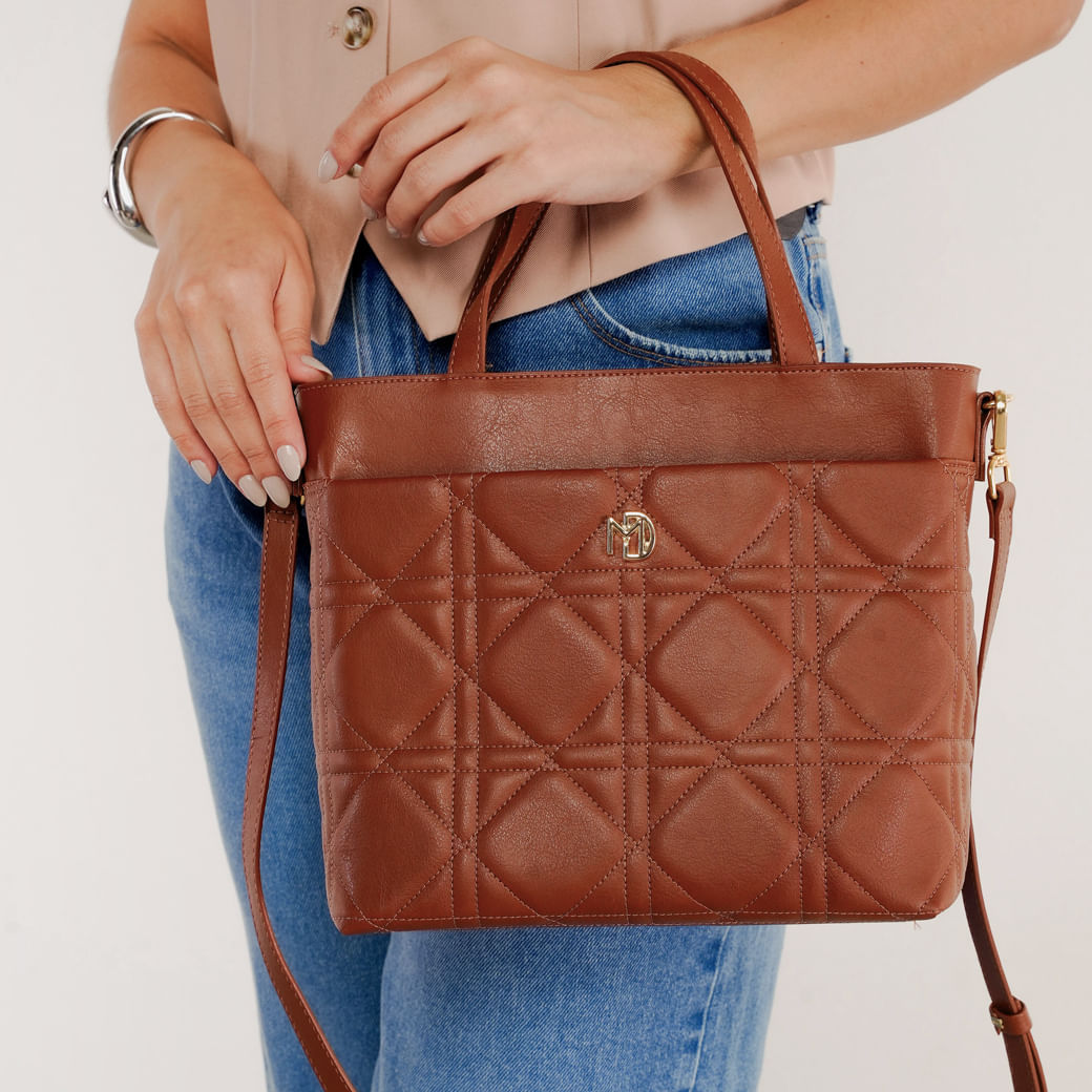 Bolsa tiracolo feminina Modare cor avelã em material sintético com acabamento acolchoado em padrão geométrico, vista frontal com alças duplas e detalhe metálico dourado