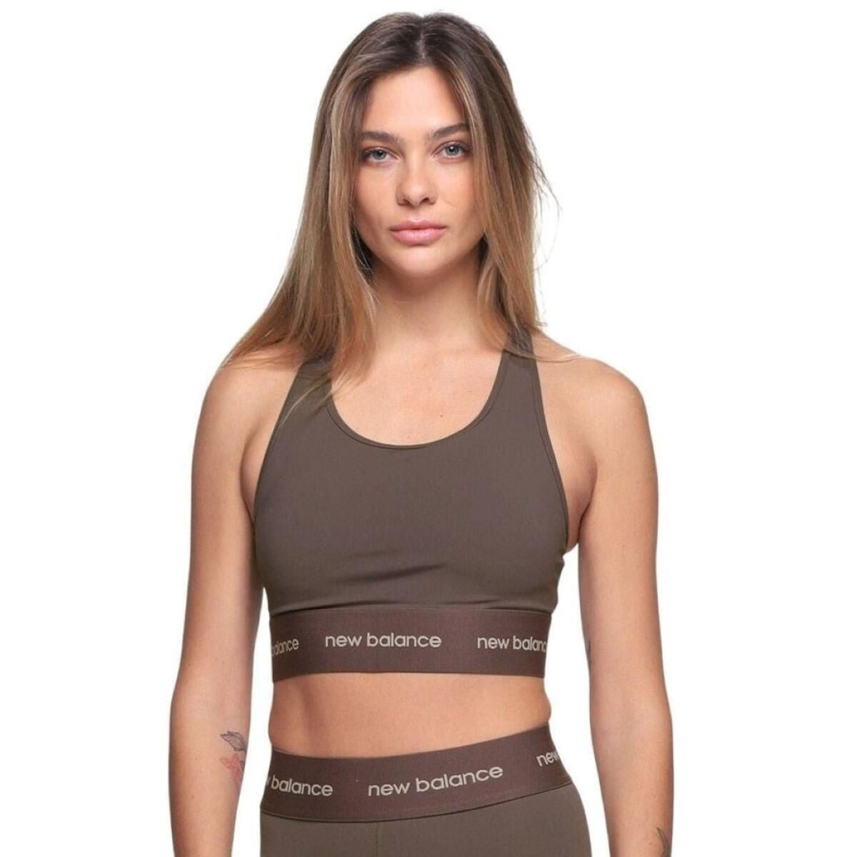Top esportivo New Balance Essentials Feminino Preto visto de lado em modelo feminino