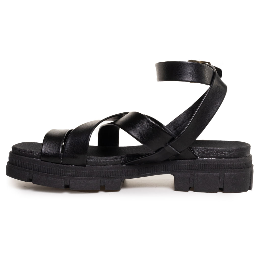 Sandália Moleca preta em fundo branco destacando sola tratorada e tiras cruzadas
