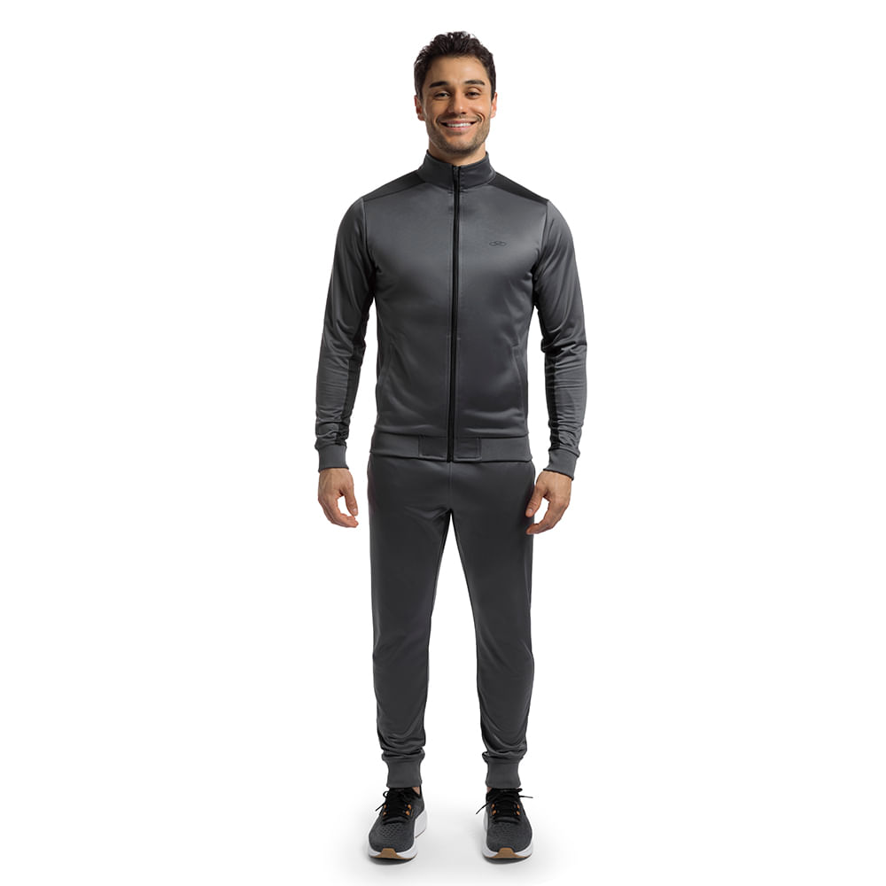 Homem vestindo Conjunto Agasalho masculino Olympikus Essential cinza com jaqueta e calça, em fundo branco