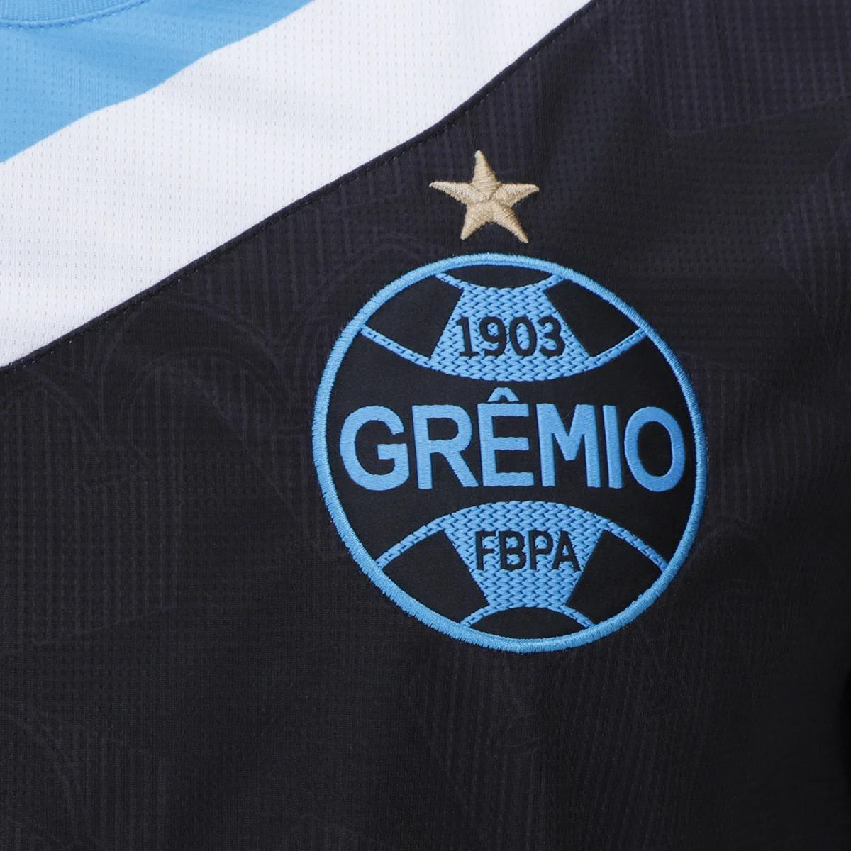 Detalhe frontal da camisa masculina Umbro Grêmio 2024 preta com escudo bordado